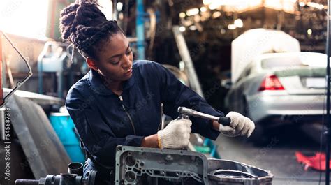 African Young Female Car Mechanic Checking And Fixing Car Engine At