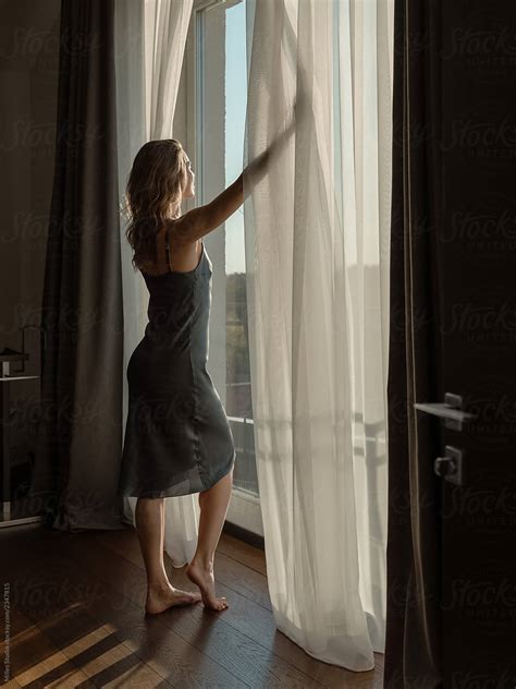 Woman Opening Curtains On Window By Stocksy Contributor Milles Studio Stocksy