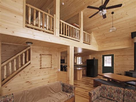 Featuring a covered front porch, stone fireplace, loft, and a cozy interior. Cabin Interior Design | Custom Cabin Floor Plans