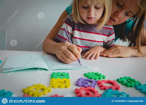 Mother Teaching Daughter How To Write Letters Royalty Free Stock Image