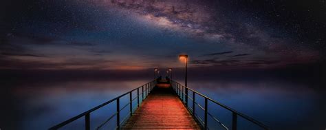 2560x1024 Ocean Pier Under Milky Way Sky 2560x1024 Resolution Wallpaper