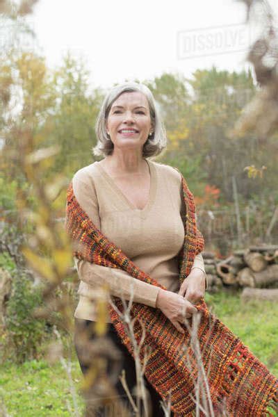 Smiling Mature Woman Looking Away While Standing At Park During Autumn