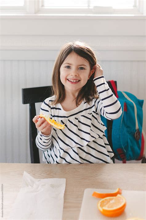 Young Girl Enjoying A Healthy After School Snack At Table Del