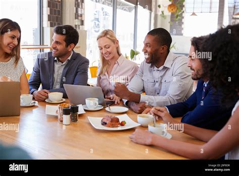 Group Of Businesspeople Having Meeting In Coffee Shop Stock Photo Alamy