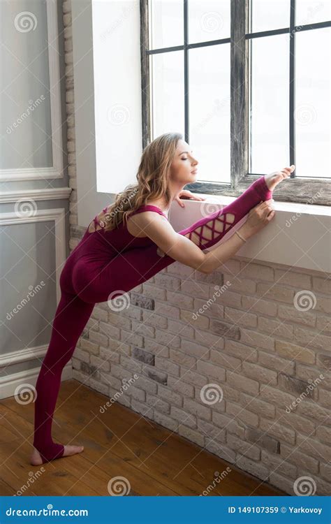 Fit Sporty Girl Is Stretching Near The Window Young Beautiful Gymnast Woman In Jumpsuit Doing