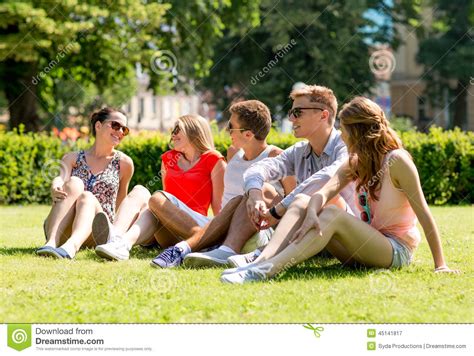 Group Of Smiling Friends Outdoors Sitting On Grass Stock Image Image