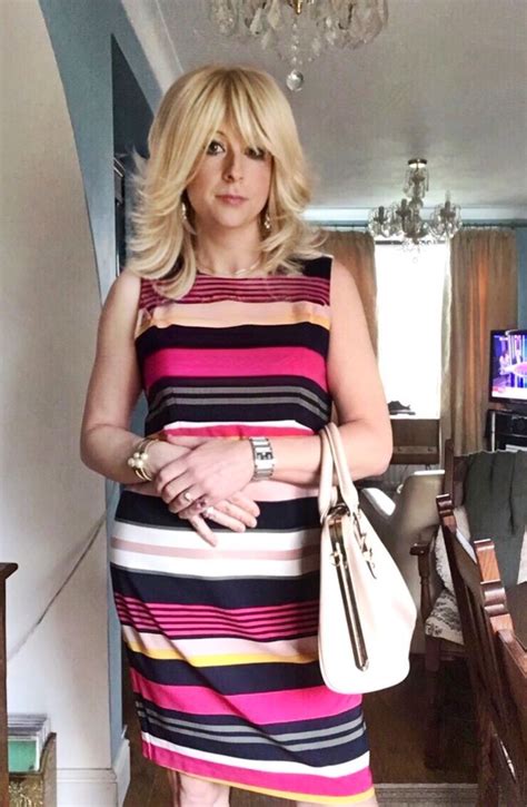 A Woman In A Striped Dress Holding A Purse