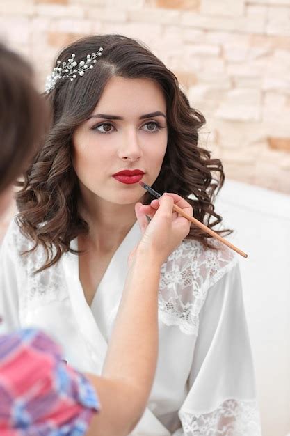 premium photo makeup artist preparing bride before her wedding