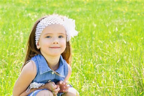 Portrait Of Adorable Smiling Little Girl On The Meadow Stock Photo