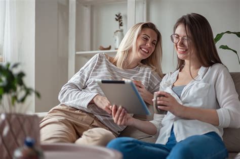 Zwei Junge Freundinnen Die Zusammen Tablet Benutzen Lächelnd Auf Der Couch Sitzen Und Spaß Haben
