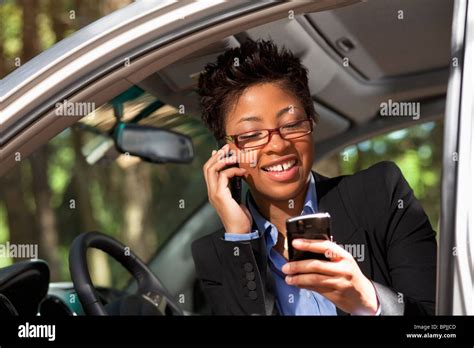Black Woman In Vehicle Using Two Cell Phones Stock Photo Alamy