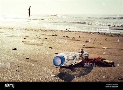 Plastic Bottle And Trash Lying On The Shore Of The Beach And Polluting