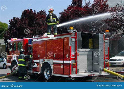Firemen Using Water Canon On Fire Truck To Put Out Apartment Fire Stock