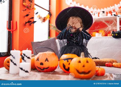 Adorable Blonde Girl Wearing Witch Costume Covering Eyes With Hands At