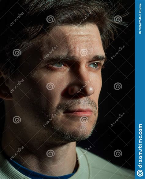 A Thoughtful Sad Man Looks To The Right Portrait In Side Light Stock