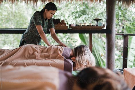 Woman Relaxing At Spa Receiving A Massage From Massage Therapist By Stocksy Contributor