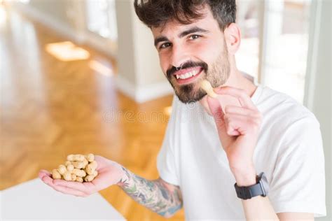 Young Man Eating Peanuts Close Up Of Hand With A Bunch Of Healthy Nuts