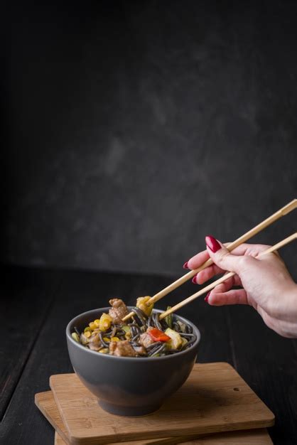 Download this chopsticks noodles photo now. Hand with chopsticks mixing in noodles bowl Photo | Free Download