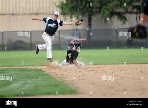 Infielder Leaps Over A Sliding Base Runner To Keep Catchers Throw From