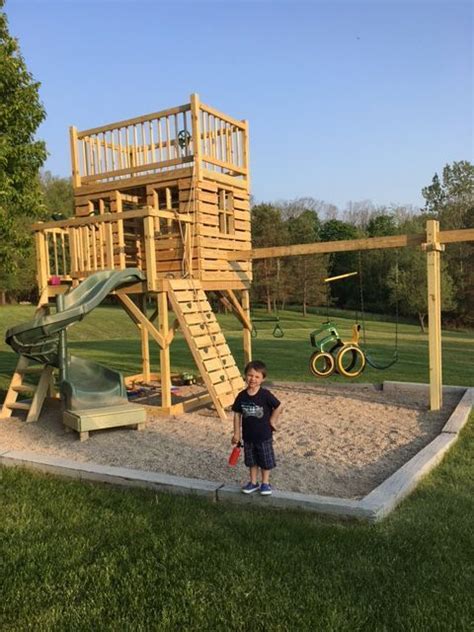 Boy Enjoying His New Three Level Clubhouse With A Slide Rock Wall