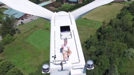 Monk Sunbathing On Wind Turbine Captured By Drone Camera Technology