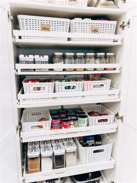 An Organized Pantry With White Bins And Baskets