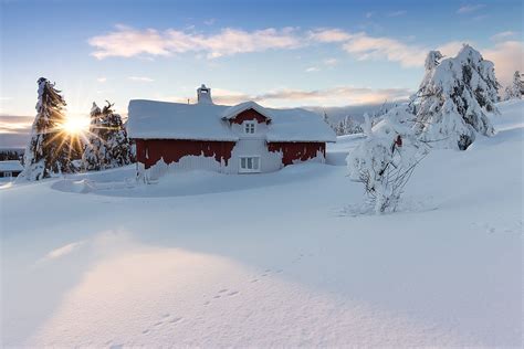 Snow Covered Log Cabin At Sunset