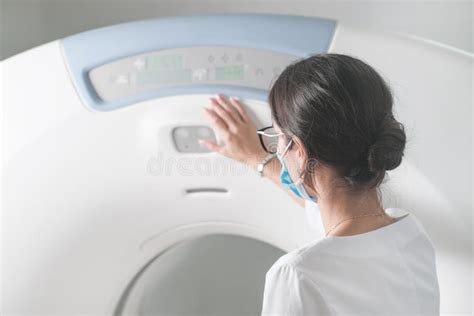 Back View Of Woman Radiologist Doctor Adjusting Computer Tomography