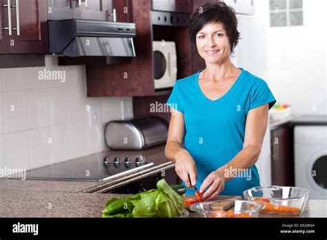 Attractive Middle Aged Woman Cooking In Kitchen Stock Photo Alamy