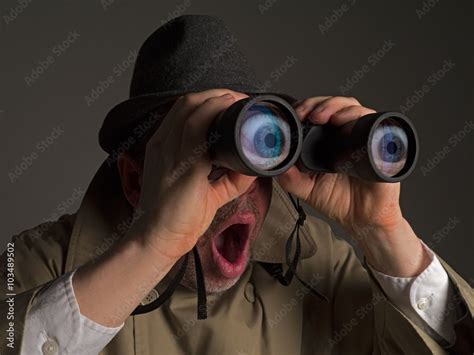 Photograph Of A Man In Trench Coat And Hat Looking Through Binoculars