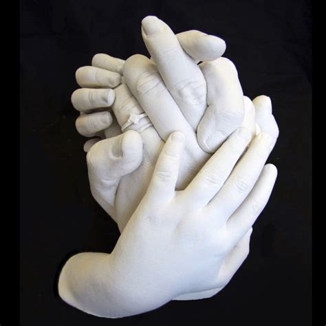 Two White Hands Holding Each Other On A Black Surface