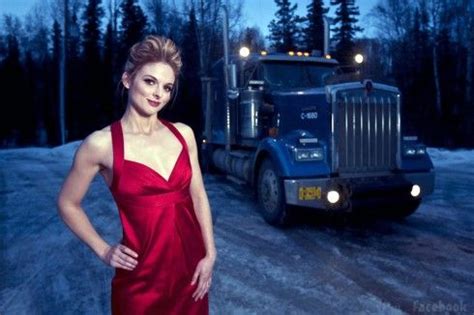 A Woman In A Red Dress Standing Next To A Semi Truck On A Snowy Road