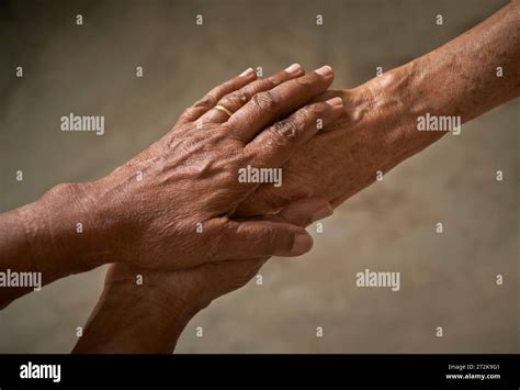 Caregiver, carer hand holding elderly hand. People helping and