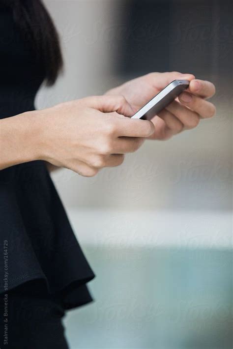 Close Up Of Hands Of A Businesswoman Holding A Mobile Phone By