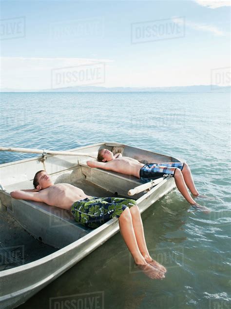 Boys 10 1112 13 Resting On Boat Stock Photo Dissolve