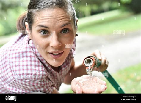 Woman Spreading Water From Garden Hose Stock Photo Alamy