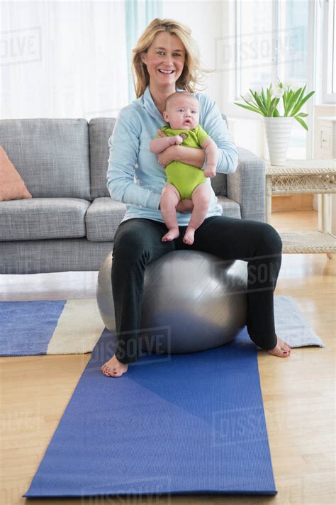 Caucasian Mother Holding Baby On Exercise Ball Stock Photo Dissolve