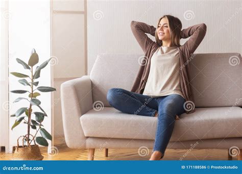 Calm Girl Enjoying Weekends Relaxing On Couch At Home Stock Photo