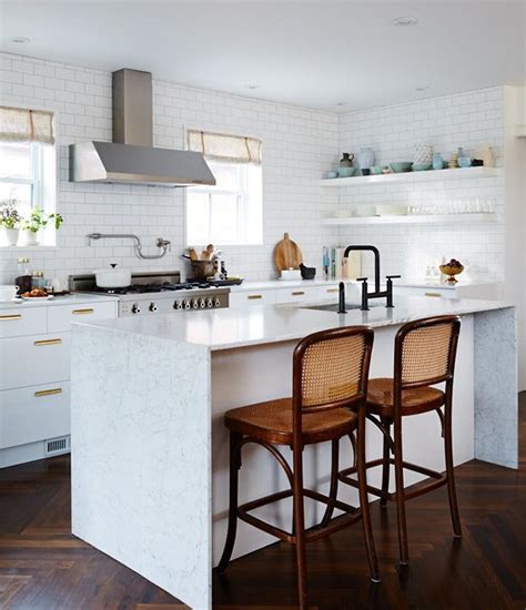 A Kitchen With An Island And Two Stools In Front Of The Stove Top Oven