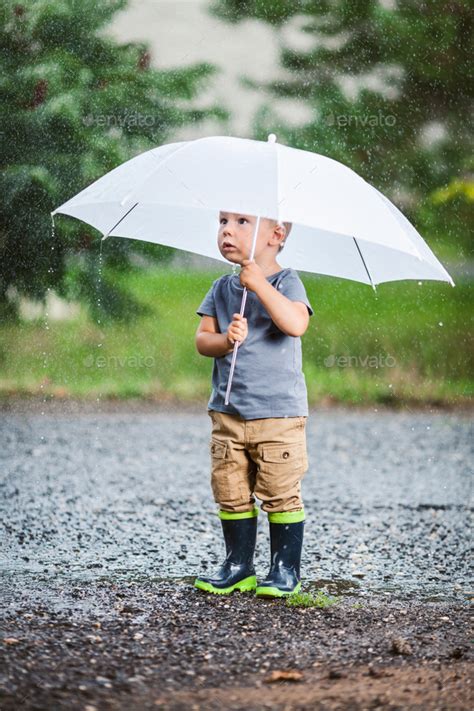 Adorable Child Holding An Umbrella In A Rain Storm Rain Storm