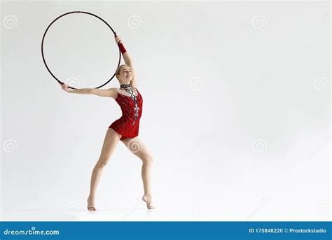 Female Gymnast Giving Performance With Hula Hoop On White Background