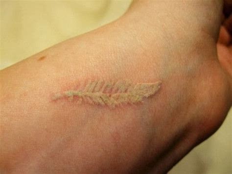 43.white ink nautical stars tattoos: Feather white ink tattoo on wrist - World Amazing Tattoos