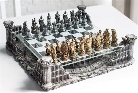 A Glass Chess Board With Gold And Silver Pieces On Its Sides Sitting