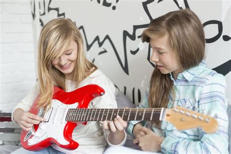 Muchacha Que Escucha La Hermana Que Toca La Guitarra Eléctrica En Casa