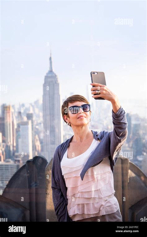 Female Tourist Takes A Selfie On Top Of The Rock Observatory With The