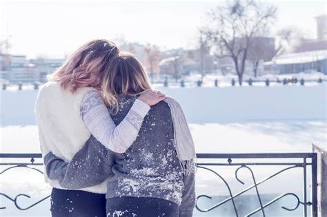 Dos Mujeres Abrazadas Están Junto Al Río Congelado Vista Trasera