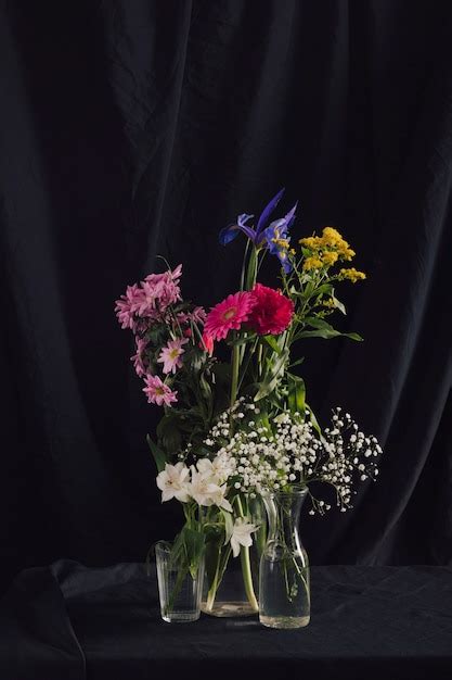 Cachos de flores coloridas em vasos com água Foto Grátis