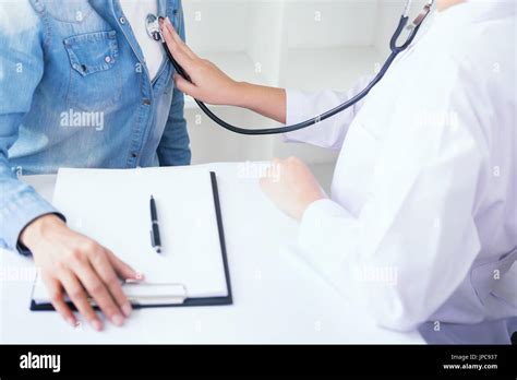 Doctor Listening To Cheerful Young Patients Chest With Stethoscope In