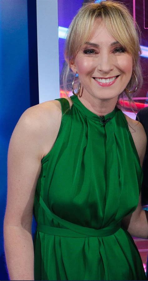 A Woman In A Green Dress Smiling For The Camera