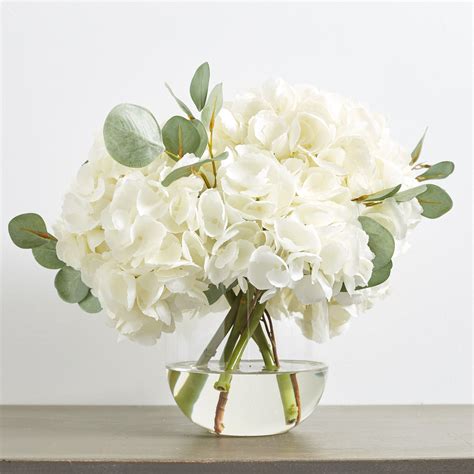 large white hydrangea and eucalyptus arrangement in rounded glass vase flower centerpieces